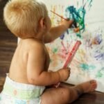 dreumes die zelf aan het knutselen is met verf op papier