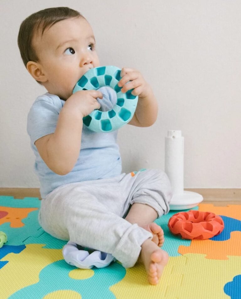 Baby die zit en aan het spelen is met speelgoed