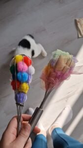Gardes gevuld met stof en pompons als activiteit voor en baby en dreumes, fijne motoriek