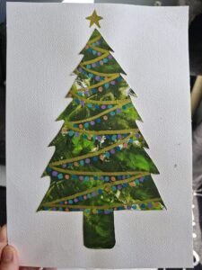 geverfde kerstboom met slingers en ballen, geverfd door een baby