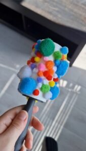 kleding roller met pompons er op activiteit voor baby's en dreumesen, fijne motoriek
