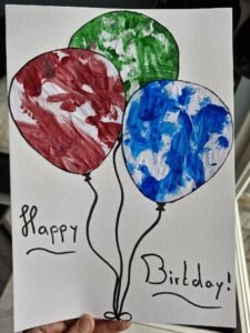 geverfde ballonnen op een papier geplakt door een baby