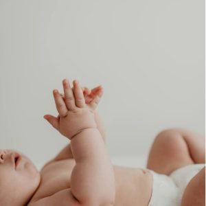 baby die op de rug ligt en in de handen klapt