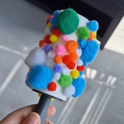 kleding roller met pompons er op activiteit voor baby's en dreumesen, fijne motoriek