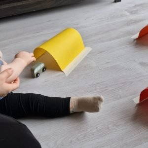activiteit 12-18 maanden. Autos onder een papieren brug duwen. kleuren brug